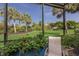 Relaxing screened-in patio with lush landscaping, chair, and a serene view of the well-manicured lawn at 8291 Varenna Dr, Sarasota, FL 34231