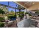 Screened-in patio featuring comfortable seating and views of the well-manicured lawn and tropical landscaping at 8291 Varenna Dr, Sarasota, FL 34231