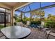 Enclosed patio area with a glass-topped table and comfortable seating, perfect for enjoying the outdoors at 8291 Varenna Dr, Sarasota, FL 34231