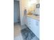 Well-lit bathroom featuring double sinks with granite counters and white cabinets at 831 Palmetto Ne Dr, Port Charlotte, FL 33952