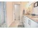 Well-lit bathroom featuring double sinks with granite counters and white cabinets at 831 Palmetto Ne Dr, Port Charlotte, FL 33952