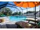 Enjoy this screened-in private pool area with lounge chairs and an umbrella perfect for relaxing at 831 Palmetto Ne Dr, Port Charlotte, FL 33952
