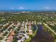 Aerial view of neighborhood homes next to a lake, near the ocean and a golf course under a beautiful blue sky at 866 Oak Briar Ln, Osprey, FL 34229