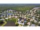 Aerial view of a home with a screened pool in a community surrounded by lakes and green spaces at 866 Oak Briar Ln, Osprey, FL 34229