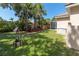Lush backyard with green grass, tropical landscaping, and a screened-in porch at 866 Oak Briar Ln, Osprey, FL 34229