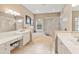 Well-lit bathroom with a soaking tub, glass-enclosed shower, and dual vanities at 866 Oak Briar Ln, Osprey, FL 34229