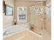 Elegant bathroom featuring a soaking tub, walk-in shower, and natural light from the window at 866 Oak Briar Ln, Osprey, FL 34229