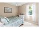 Charming bedroom with a bed, white dresser, and window with sheer curtains at 866 Oak Briar Ln, Osprey, FL 34229