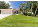 Charming single-story home with a well-manicured lawn, lush landscaping, and an attached two-car garage at 866 Oak Briar Ln, Osprey, FL 34229