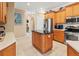 Modern kitchen with stainless steel appliances, a granite countertop island, and warm wood cabinets at 866 Oak Briar Ln, Osprey, FL 34229