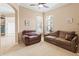 Cozy living room featuring comfortable seating, neutral colors, and bright light from shuttered windows at 866 Oak Briar Ln, Osprey, FL 34229