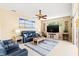 Comfortable living room with plush blue furniture, a ceiling fan, and beach-themed artwork at 866 Oak Briar Ln, Osprey, FL 34229