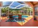 Relaxing screened pool area with lounge chairs, table, umbrella, and lush landscaping at 866 Oak Briar Ln, Osprey, FL 34229