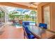 Screened pool area with dining table, chairs, and lounge chairs with lush landscaping at 866 Oak Briar Ln, Osprey, FL 34229