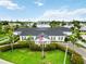 Aerial view of a clubhouse with lush landscaping, an American flag, and a view of a pond at 9412 Concord Cir, Bradenton, FL 34210