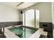 Indoor hot tub surrounded by light tile, steel rails, and glass block windows providing natural light at 9412 Concord Cir, Bradenton, FL 34210