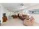 Cozy living room featuring comfortable seating, neutral carpet, and sliding glass doors leading to sunroom at 9412 Concord Cir, Bradenton, FL 34210