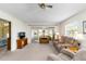 Comfortable living room with a ceiling fan and sliding glass doors to the sunroom with plush seating at 9412 Concord Cir, Bradenton, FL 34210