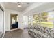 Comfortable sunroom with a floral sofa and ample natural light streaming through multiple windows and a door at 9412 Concord Cir, Bradenton, FL 34210