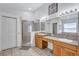Bright bathroom featuring a double vanity, a large mirror, and a walk-in shower at 1126 Barclay Wood Dr, Ruskin, FL 33570