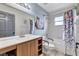 A bright bathroom with a wooden vanity, decorated shower curtain and grab bars on the toilet at 1126 Barclay Wood Dr, Ruskin, FL 33570