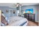 Spacious bedroom with a ceiling fan, TV, dark wood floors, and a desk area at 1126 Barclay Wood Dr, Ruskin, FL 33570