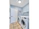 Well-lit laundry room with tile floors, modern appliances, and wall mounted shelving at 1126 Barclay Wood Dr, Ruskin, FL 33570