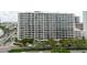 A front exterior view of a high-rise condominium building with many windows, balconies, and street view at 1255 N Gulfstream Ave # 1104, Sarasota, FL 34236