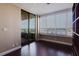 Living room with sliding door to a balcony and an ocean view through shuttered windows at 1255 N Gulfstream Ave # 1104, Sarasota, FL 34236