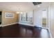 Open living room with hardwood flooring, white shutters, and a glass patio door at 1255 N Gulfstream Ave # 1104, Sarasota, FL 34236