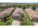 Stunning aerial view of the home with tile roof, brick driveway, and lush landscaping by the pond at 13338 Torresina Ter, Lakewood Ranch, FL 34211