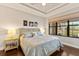 Bright bedroom features tray ceilings, hardwood floors, and an oversized window with view at 13338 Torresina Ter, Lakewood Ranch, FL 34211