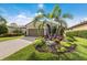 Charming exterior with lush landscaping, palm trees and a paver driveway leading to the garage at 13338 Torresina Ter, Lakewood Ranch, FL 34211