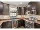 Well-appointed kitchen featuring dark cabinetry, granite countertops, stainless steel appliances, and a wine cooler at 13338 Torresina Ter, Lakewood Ranch, FL 34211