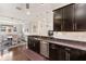 Open-concept kitchen with stainless steel appliances, granite countertops, dark cabinets, and a view of the dining area at 13338 Torresina Ter, Lakewood Ranch, FL 34211