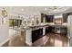 Bright and airy kitchen featuring stainless steel appliances, dark cabinets, granite counters, and hardwood floors at 13338 Torresina Ter, Lakewood Ranch, FL 34211