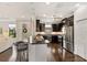Spacious kitchen with stainless appliances, dark cabinets, granite counters, and hardwood flooring at 13338 Torresina Ter, Lakewood Ranch, FL 34211
