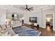 Open-concept living room with hardwood floors, a modern ceiling fan, and seamless flow to the kitchen at 13338 Torresina Ter, Lakewood Ranch, FL 34211