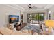 Bright living room boasts a scenic view with a sliding glass door to the screened in patio and pool area at 13338 Torresina Ter, Lakewood Ranch, FL 34211