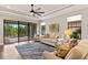 Inviting living room with tray ceilings, a ceiling fan, neutral décor, and a view of the screened-in lanai at 13338 Torresina Ter, Lakewood Ranch, FL 34211
