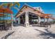 Outdoor dining area with tables, chairs, umbrellas, and palm trees at the clubhouse at 13338 Torresina Ter, Lakewood Ranch, FL 34211