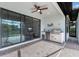 A covered patio area with stone flooring, a built-in outdoor kitchen, and sliding glass doors into the home at 13338 Torresina Ter, Lakewood Ranch, FL 34211
