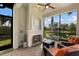 Relaxing screened lanai with fireplace, comfortable seating, and serene lake view at 13338 Torresina Ter, Lakewood Ranch, FL 34211