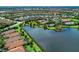Community aerial view featuring a lake, tennis courts, playground, and manicured landscaping at 13609 Messina Loop # 104, Bradenton, FL 34211
