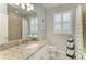 Bright bathroom featuring granite countertop, white cabinets, and shower with blue accents at 13609 Messina Loop # 104, Bradenton, FL 34211