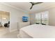 This bedroom includes a ceiling fan, a TV, and large windows with golf course views at 13609 Messina Loop # 104, Bradenton, FL 34211