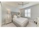 Stylish bedroom featuring a tufted headboard, ceiling fan, and shutters at 13609 Messina Loop # 104, Bradenton, FL 34211