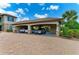Covered carport with brick driveway featuring two parked cars, adding convenience and protection at 13609 Messina Loop # 104, Bradenton, FL 34211