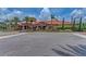 Exterior of a large community clubhouse featuring a red tile roof, manicured landscaping, and spacious parking at 13609 Messina Loop # 104, Bradenton, FL 34211