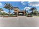 Grand entrance to the community, framed by palm trees and colorful landscaping at 13609 Messina Loop # 104, Bradenton, FL 34211